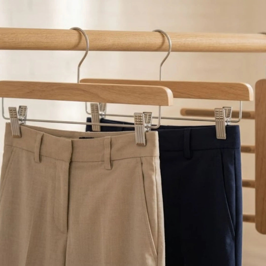 Cintres à pinces gainées tenant des pantalons repassés par l'ourlet