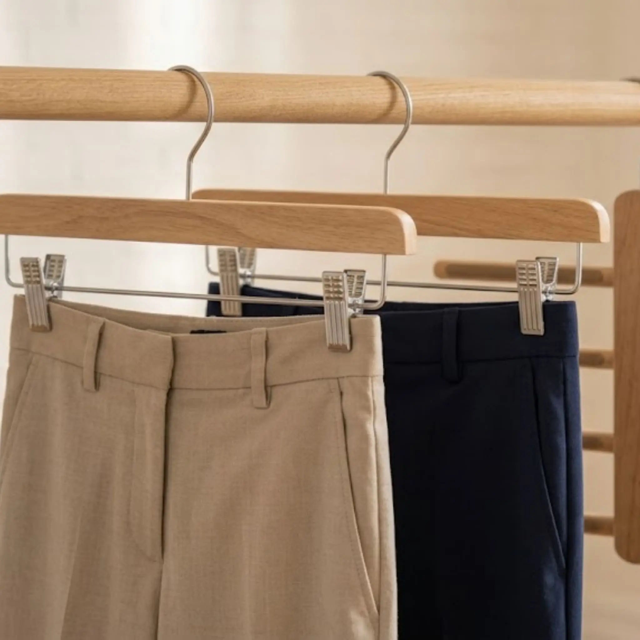 Cintres à pinces gainées tenant des pantalons repassés par l'ourlet