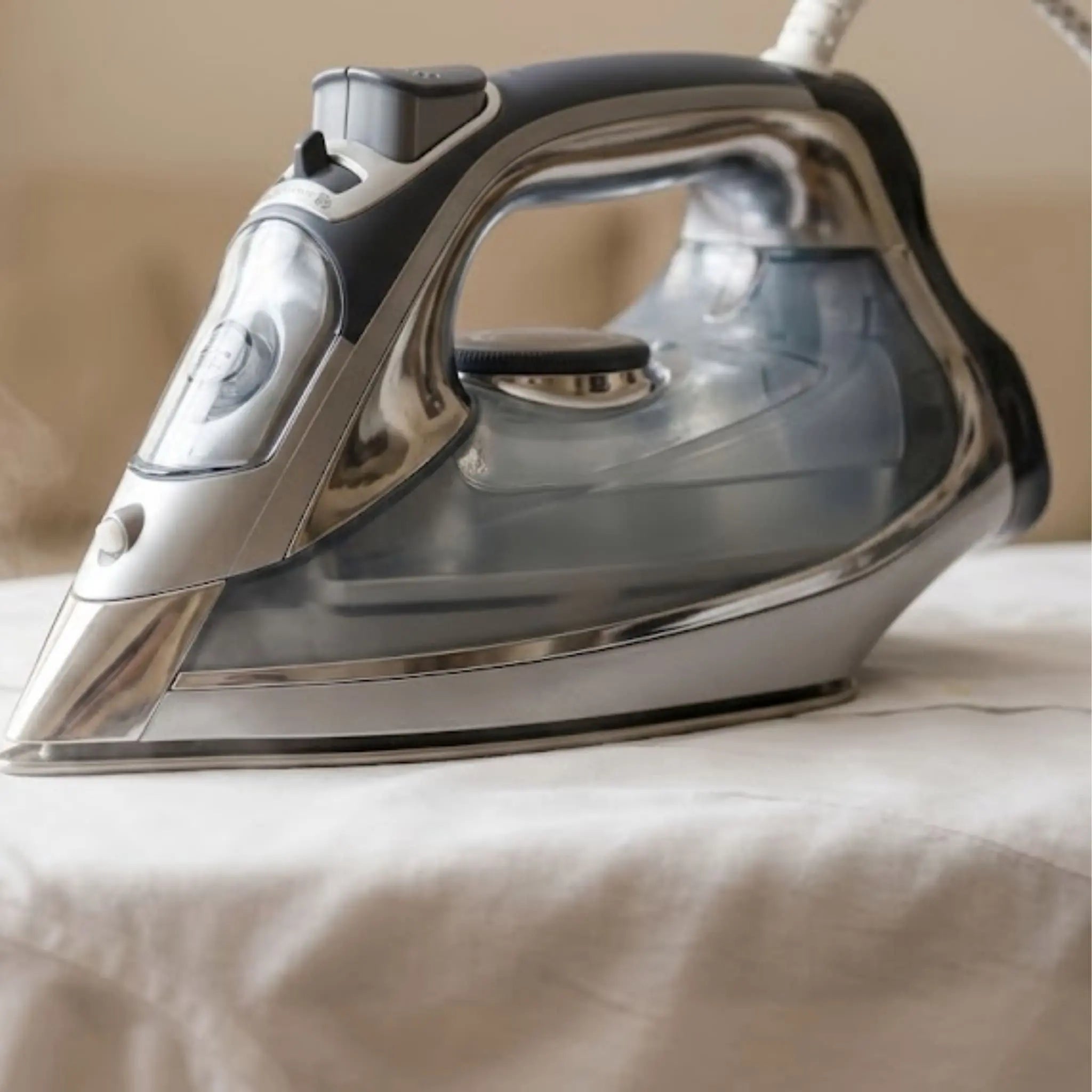 Fer à repasser vapeur à semelle inox glissant sur une chemise blanche