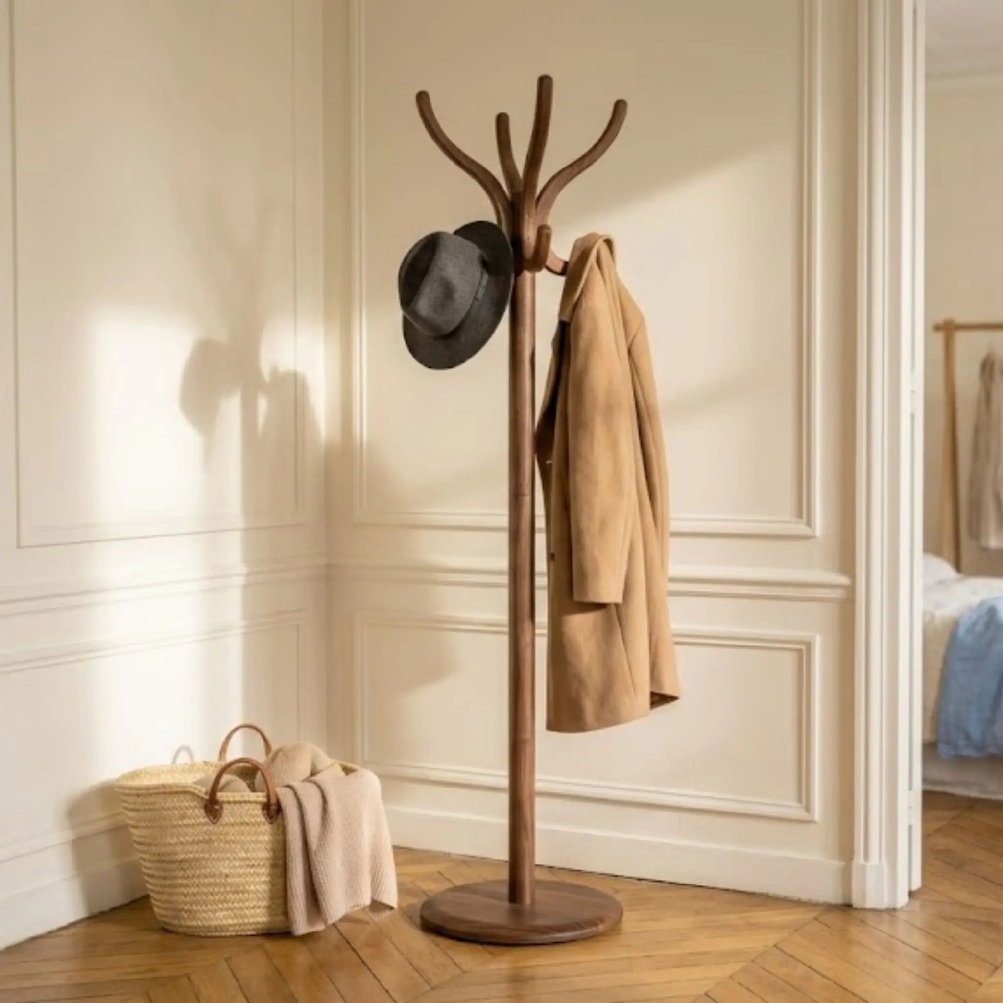 Porte-manteau sur pied en bois foncé avec trench et chapeau dans une chambre Bild